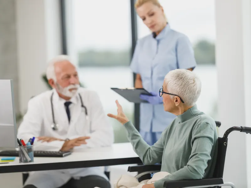 Médico atendendo paciente acompanhado da equipe
